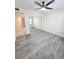 Bright bedroom featuring a ceiling fan, wood-look flooring, and mirrored closet doors at 8300 Bardmoor Blvd # 110, Seminole, FL 33777
