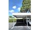Assigned carport parking with clearly marked spaces and mature landscaping nearby at 8300 Bardmoor Blvd # 110, Seminole, FL 33777