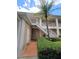 Exterior shot of a condo building with a stairway and lush tropical landscaping at 8300 Bardmoor Blvd # 110, Seminole, FL 33777