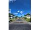 Quiet street lined with well-kept homes, lush lawns, and mature trees under a sunny, blue sky at 8300 Bardmoor Blvd # 110, Seminole, FL 33777