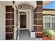 Front porch with detailed trim and a brown front door at 916 48Th Street E Dr, Bradenton, FL 34208