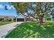 Charming home featuring a well-maintained lawn, mature tree, and a two-car garage at 916 48Th Street E Dr, Bradenton, FL 34208