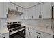 This modern kitchen features white cabinets, stainless steel appliances, and quartz countertops at 916 48Th Street E Dr, Bradenton, FL 34208