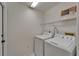 Functional laundry room featuring a washer, dryer, wire shelving, and neutral walls at 916 48Th Street E Dr, Bradenton, FL 34208