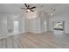 Open-concept living room with light wood floors, ceiling fan, and sliding glass doors to the patio at 916 48Th Street E Dr, Bradenton, FL 34208