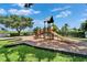 Community playground with a slide, set against a backdrop of lush greenery and clear skies at 916 48Th Street E Dr, Bradenton, FL 34208