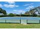 Well-maintained tennis court surrounded by greenery, perfect for an active lifestyle at 916 48Th Street E Dr, Bradenton, FL 34208