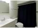 Bright bathroom featuring a modern sink, toilet, and shower with a dark shower curtain at 945 Hamilton Ct, Palm Harbor, FL 34683