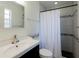 Bright bathroom featuring tile accents, a modern sink, toilet, and a white shower curtain at 945 Hamilton Ct, Palm Harbor, FL 34683