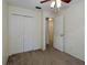 Cozy bedroom features neutral carpet and paint, along with a ceiling fan and closet at 945 Hamilton Ct, Palm Harbor, FL 34683