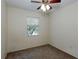 Bedroom with neutral carpet and paint, featuring a ceiling fan and natural light from a window at 945 Hamilton Ct, Palm Harbor, FL 34683