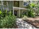 Charming green home with a welcoming front entrance and tropical landscaping at 945 Hamilton Ct, Palm Harbor, FL 34683