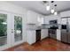 Bright kitchen featuring white cabinets, stainless steel appliances, terra-cotta tile flooring, and access to a patio at 945 Hamilton Ct, Palm Harbor, FL 34683