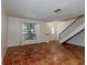 Open living room with terracotta tile and staircase, filled with natural light at 945 Hamilton Ct, Palm Harbor, FL 34683