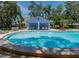 Community pool area featuring a pool house, tables and chairs, and a sparkling swimming pool at 945 Hamilton Ct, Palm Harbor, FL 34683