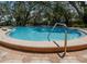 Community pool with clear blue water, a brick paver deck, and plenty of space for relaxation at 945 Hamilton Ct, Palm Harbor, FL 34683