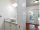 Stylish powder room with granite countertop, modern sink, and access to outdoor patio at 945 Hamilton Ct, Palm Harbor, FL 34683