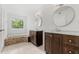 Bathroom featuring double vanities, soaking tub, and tile accents, creating a relaxing space at 9481 Highland Oak Dr # 212, Tampa, FL 33647