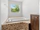 Bright bathroom showcasing a soaking tub and tiled surround, offering a spa-like experience at 9481 Highland Oak Dr # 212, Tampa, FL 33647