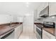 Kitchen features white cabinets, stainless appliances, tiled backsplash and a large sink at 9481 Highland Oak Dr # 212, Tampa, FL 33647