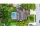 Aerial view of the home featuring a screened pool, solar panels, and putting green at 10053 W Bay St, Seminole, FL 33776