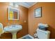 Bathroom features a pedestal sink, tiled floor, decorative mirror and paint at 10053 W Bay St, Seminole, FL 33776