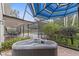 Inviting hot tub on brick patio with a view of the screened-in pool and backyard at 10053 W Bay St, Seminole, FL 33776
