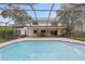 A large backyard pool with a screened-in enclosure, patio, and access to the home at 10053 W Bay St, Seminole, FL 33776