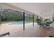 Relaxing screened-in pool area with a patio table and chairs for outdoor dining at 10053 W Bay St, Seminole, FL 33776