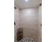 Spacious walk-in shower with beautiful travertine-look tile walls and pebble floor at 10053 W Bay St, Seminole, FL 33776