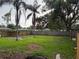 View of a large backyard with a wooden fence and mature trees at 104 W Wildwood St, Tampa, FL 33613