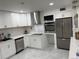 Beautiful updated kitchen with stainless steel appliances and white cabinetry at 104 W Wildwood St, Tampa, FL 33613