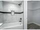Bathroom bathtub and shower featuring marble-look tiling and a built-in soap niche at 10520 White Lake Ct # 10520, Tampa, FL 33626