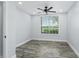 An empty bedroom featuring a ceiling fan, wood-look flooring, neutral paint, and a window at 10520 White Lake Ct # 10520, Tampa, FL 33626