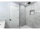 Bathroom shower featuring marble-look tiling, a glass shower door, and a built-in soap niche at 10520 White Lake Ct # 10520, Tampa, FL 33626