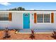 Close up of a turquoise front door with decorative wood shutters and landscaping at 11520 Meadow Dr, Port Richey, FL 34668