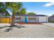 Well-maintained home featuring a landscaped yard, bright blue door, and an attached garage at 11520 Meadow Dr, Port Richey, FL 34668