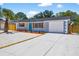 Charming single-story home with a vibrant blue door, well-maintained landscaping, and a spacious driveway at 11520 Meadow Dr, Port Richey, FL 34668