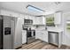 Bright kitchen features stainless steel appliances, white cabinets and countertops, and an exterior door at 11520 Meadow Dr, Port Richey, FL 34668