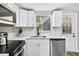 Bright kitchen features stainless steel appliances, white cabinets and countertops, and subway tile backsplash at 11520 Meadow Dr, Port Richey, FL 34668
