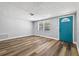 Cozy living room featuring wood floors, fresh paint, a bright window, and a turquoise door at 11520 Meadow Dr, Port Richey, FL 34668