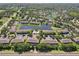 Aerial view of community with a pool, central pond, and tree lined streets at 12228 Foxmoor Peak Dr, Riverview, FL 33579