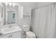 Clean bathroom with a white vanity, toilet, shower with curtain, and wall storage cabinet at 12228 Foxmoor Peak Dr, Riverview, FL 33579