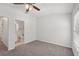 This cozy bedroom has plush carpet, a ceiling fan, a window, and an adjacent bathroom at 12228 Foxmoor Peak Dr, Riverview, FL 33579