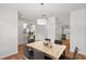 Dining room with a stylish light fixture and wood table adjoining an updated kitchen at 12228 Foxmoor Peak Dr, Riverview, FL 33579