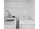 Convenient laundry area with a modern washing machine and dryer and wire rack shelving at 12228 Foxmoor Peak Dr, Riverview, FL 33579