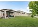 Expansive backyard featuring a covered patio with seating, a white fence, and well-maintained lawn at 12451 Nouveau Ave, Spring Hill, FL 34610