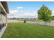 Spacious backyard with lush green grass, a white fence, and views of the neighborhood pond at 12451 Nouveau Ave, Spring Hill, FL 34610