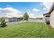 Serene backyard with a green lawn, white picket fence, and view of neighboring homes and the surrounding landscape at 12451 Nouveau Ave, Spring Hill, FL 34610