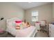 Cozy bedroom features a white bed frame, desk, and plush decor at 12451 Nouveau Ave, Spring Hill, FL 34610